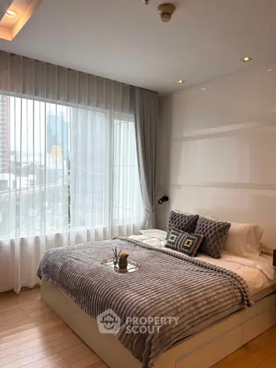 Modern bedroom with large window and cozy decor in urban apartment