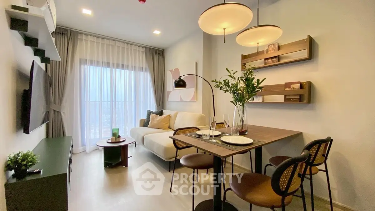 Modern living room with stylish decor and dining area, featuring large window and cozy ambiance.