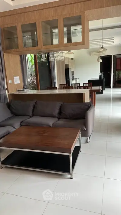 Spacious modern living room with sleek furniture and open kitchen layout.