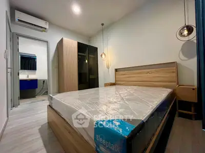 Modern bedroom with stylish lighting and sleek furniture, featuring a comfortable bed and ample storage space.