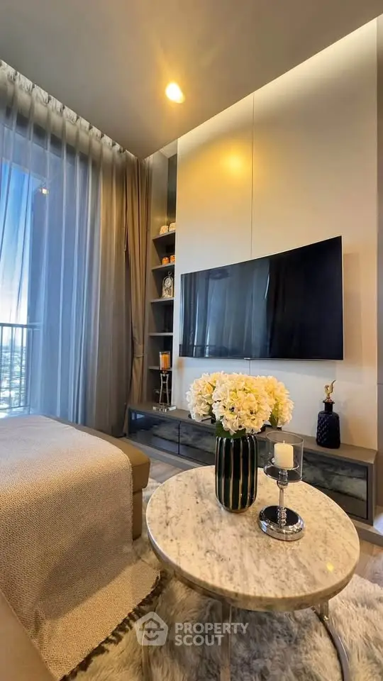 Luxurious living room with modern decor, large TV, and elegant marble coffee table.