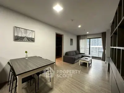 Modern living room with sleek furniture and large windows offering city views.