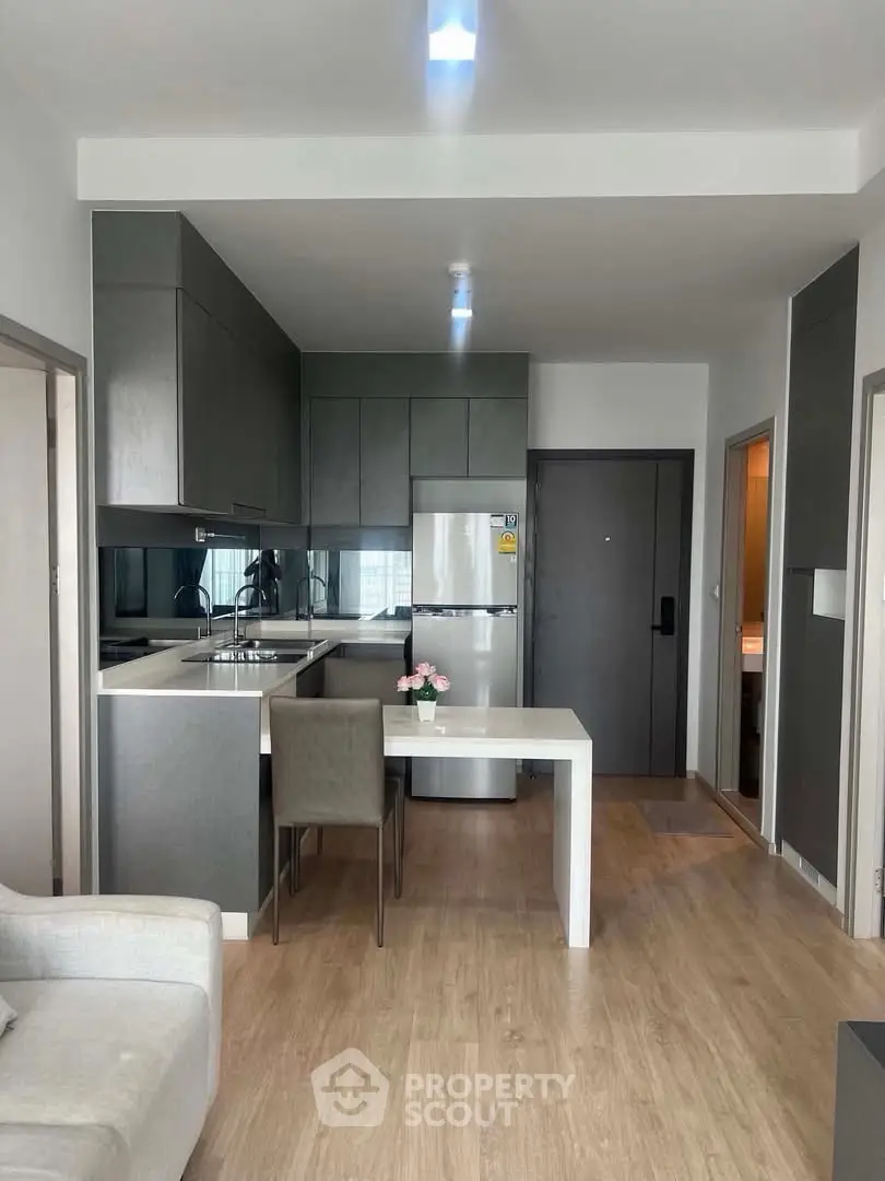 Modern kitchen with sleek cabinetry and dining area in open layout apartment