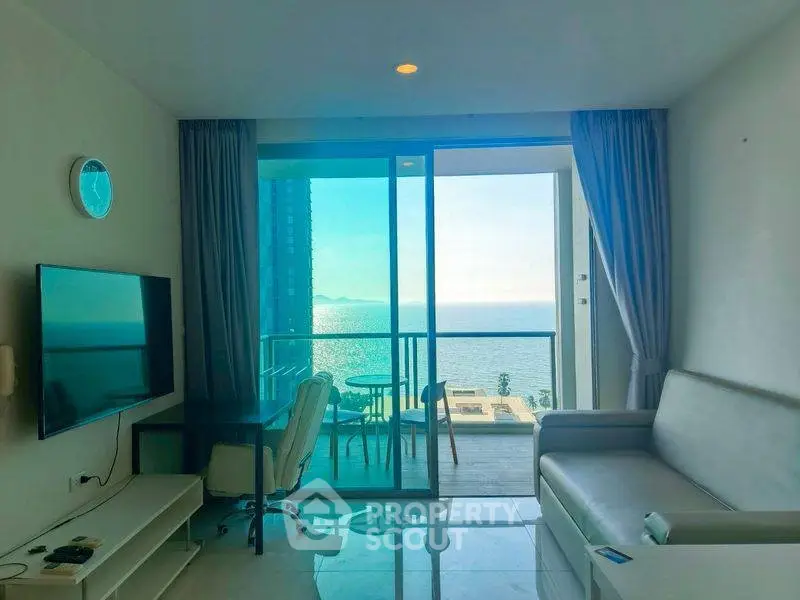 Modern living room with ocean view and balcony access in luxury apartment.