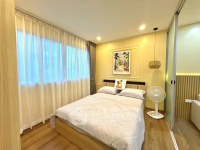 Cozy bedroom with wooden flooring, large window, and modern decor in a stylish apartment.