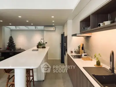 Modern kitchen with sleek design and open layout, featuring a spacious island and elegant lighting.