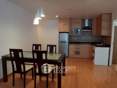 Modern open-layout kitchen and dining area with wooden flooring and stylish lighting.