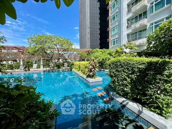 Luxurious residential pool surrounded by lush greenery and modern architecture.