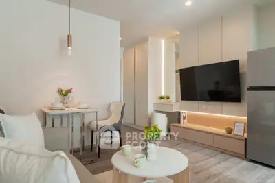 Modern living room with stylish decor and open layout, featuring a wall-mounted TV and cozy dining area.