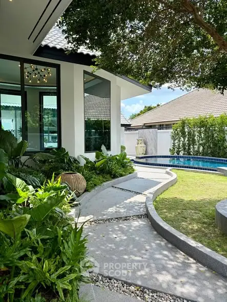 Luxurious modern home with lush garden and private pool, perfect for serene living.