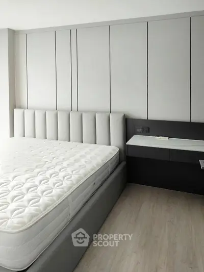 Modern bedroom with sleek design and comfortable mattress in a stylish apartment.