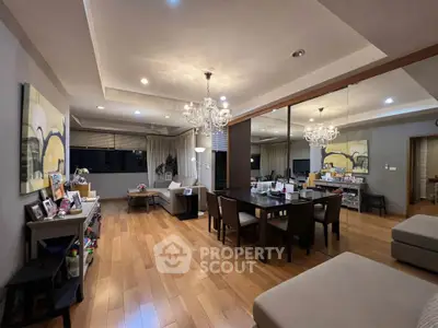 Spacious modern living room with elegant chandelier and wooden flooring