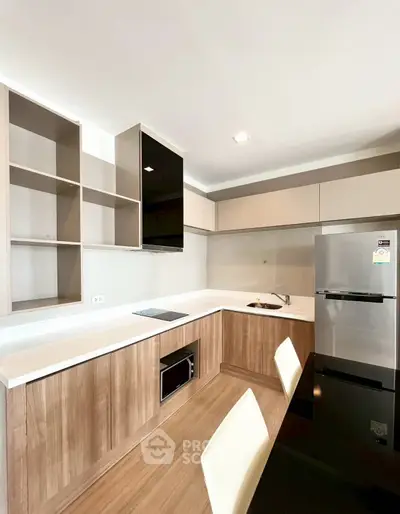 Modern kitchen with sleek cabinetry and stainless steel appliances in a contemporary apartment.