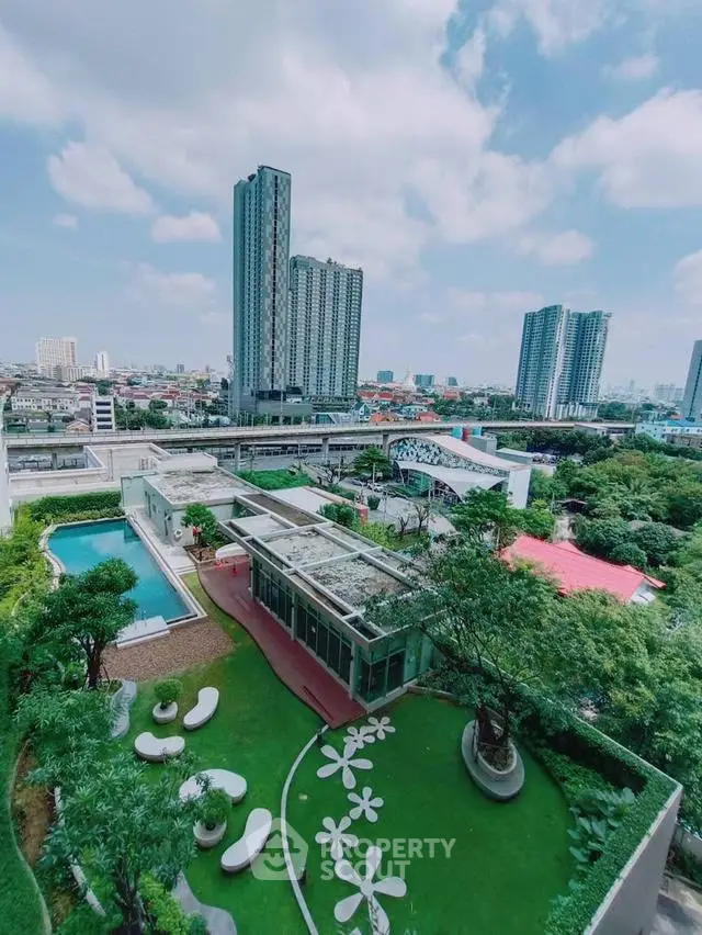 Stunning aerial view of modern residential complex with lush garden and pool, perfect urban living.