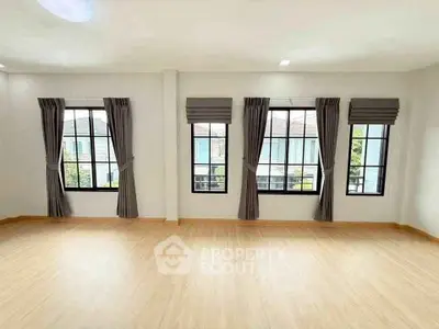 Spacious room with large windows and elegant curtains, perfect for natural light lovers.