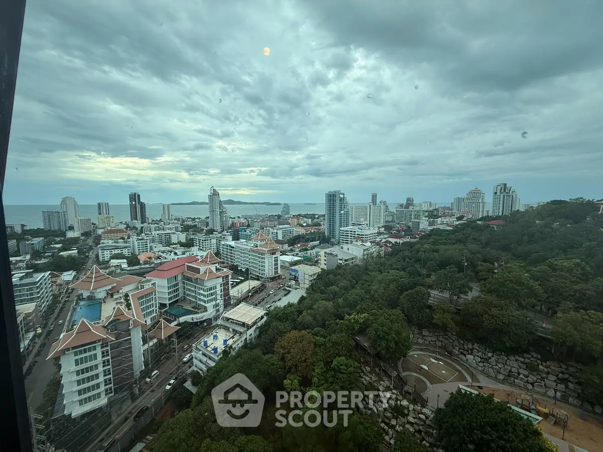 Stunning cityscape view from high-rise building overlooking urban skyline and lush greenery.