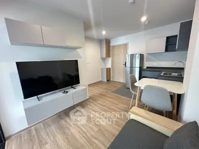 Modern open-plan living room with sleek kitchen and dining area, featuring contemporary furniture and stylish decor.