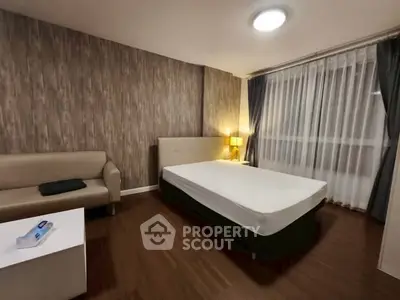 Spacious bedroom with modern decor and large window for natural light