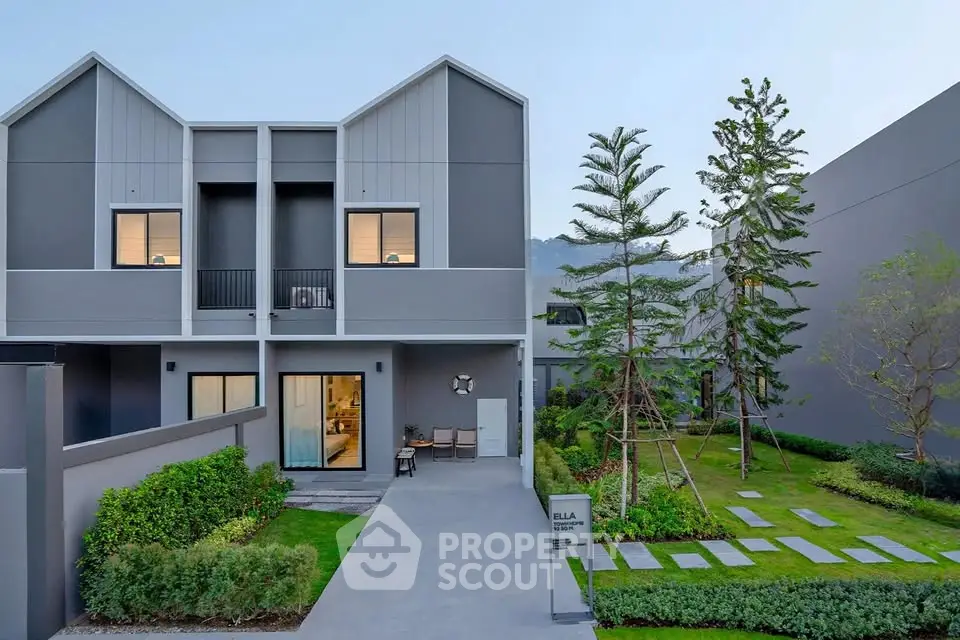 Modern townhouse with sleek design and lush garden in serene neighborhood.