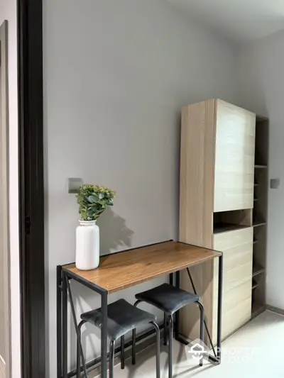 Modern compact study area with wooden desk and storage unit in stylish apartment.