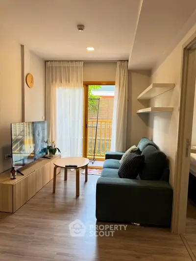 Modern living room with cozy sofa, TV, and balcony view in stylish apartment.