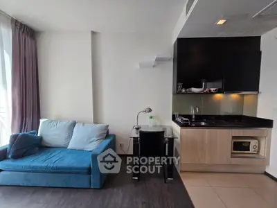 Modern studio apartment with cozy living area and compact kitchen, featuring sleek design and natural light.