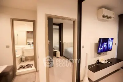 Modern apartment interior with living room, bathroom, and bedroom view, featuring sleek design and air conditioning.