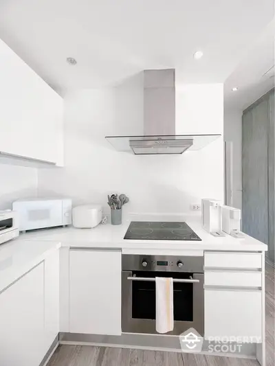 Modern kitchen with sleek white cabinets and built-in oven