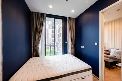 Modern bedroom with large window and stylish decor in urban apartment