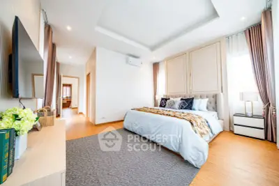 Spacious and bright bedroom with modern decor and large windows.