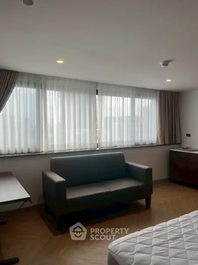 Modern living room with large windows and stylish furniture in a cozy apartment.
