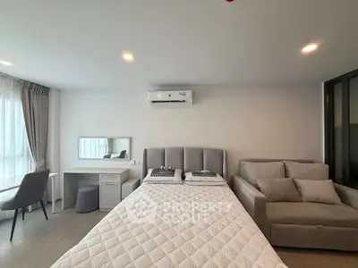 Modern bedroom with stylish decor, featuring a cozy bed, elegant sofa, and a sleek desk under soft lighting.