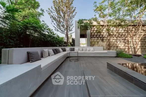 Modern outdoor patio with sleek seating and lush greenery