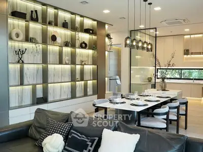 Luxurious open-plan living room and kitchen with modern decor and elegant lighting.