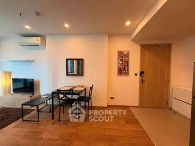 Modern living room with dining area, wooden flooring, and stylish decor in a cozy apartment.