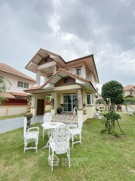 Charming two-story house with elegant garden and outdoor seating in serene neighborhood.
