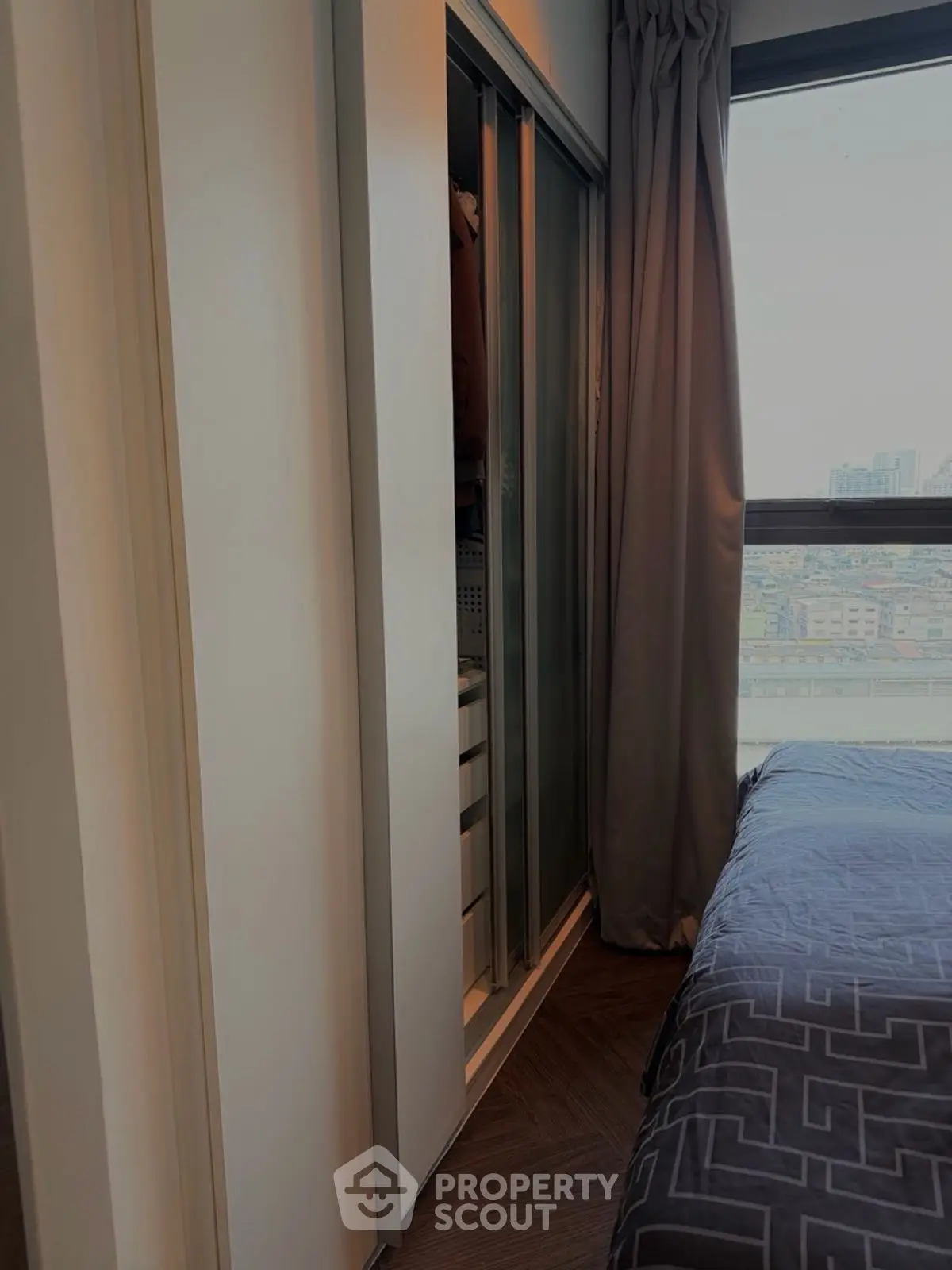 Modern bedroom with city view and sleek closet design