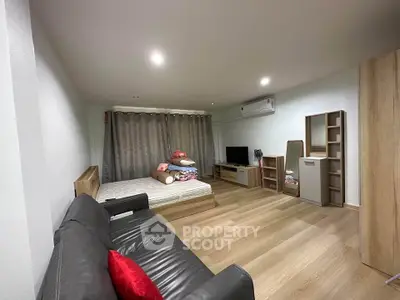 Spacious modern bedroom with cozy furnishings and sleek wooden flooring