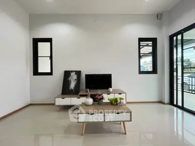 Modern living room with sleek furniture and large windows offering natural light.