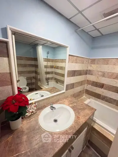 Charming bathroom with elegant marble tiles and modern fixtures, perfect for a cozy home retreat.