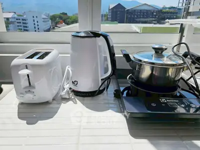 Modern kitchen appliances on a sunlit countertop with scenic view.