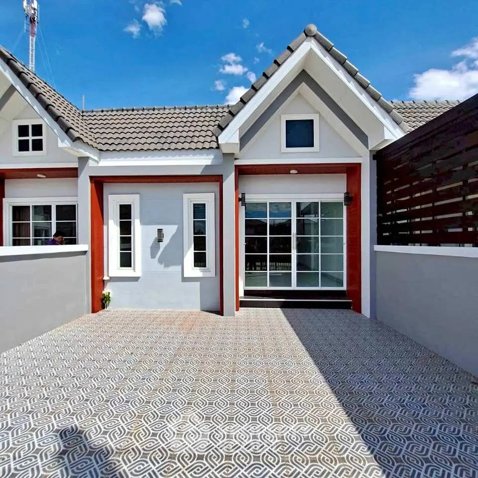 Charming single-story home with modern facade and spacious driveway under clear blue skies.
