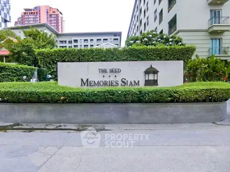 Elegant entrance of The Seed Memories Siam with lush greenery and modern architecture.