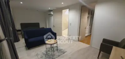 Modern living room with cozy seating and stylish decor in open layout apartment.