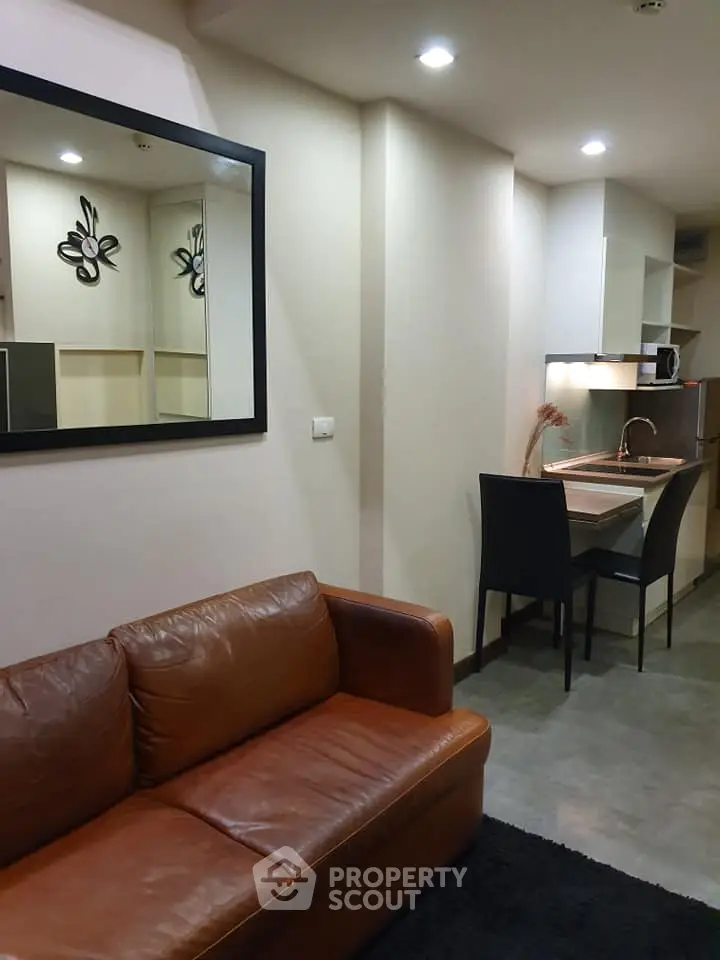 Modern living room with leather sofa and compact kitchen area