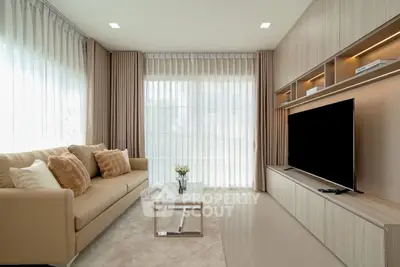 Modern living room with sleek furniture and large TV, featuring floor-to-ceiling windows and elegant decor.