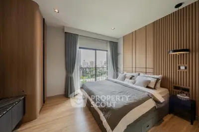 Luxurious bedroom with city view, featuring modern decor and large windows for natural light.