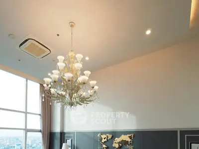 Luxurious high-ceiling living room with elegant chandelier and large windows offering city views.