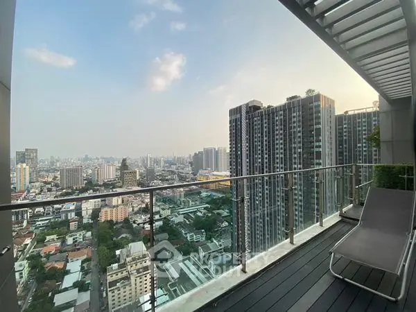 Stunning cityscape view from a modern high-rise balcony with sleek glass railing.