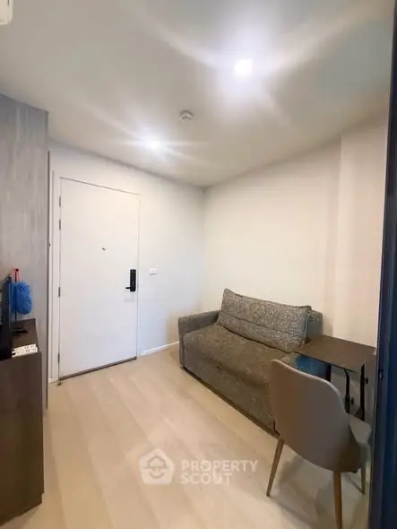 Cozy living room with modern sofa and sleek wooden flooring, perfect for relaxation.